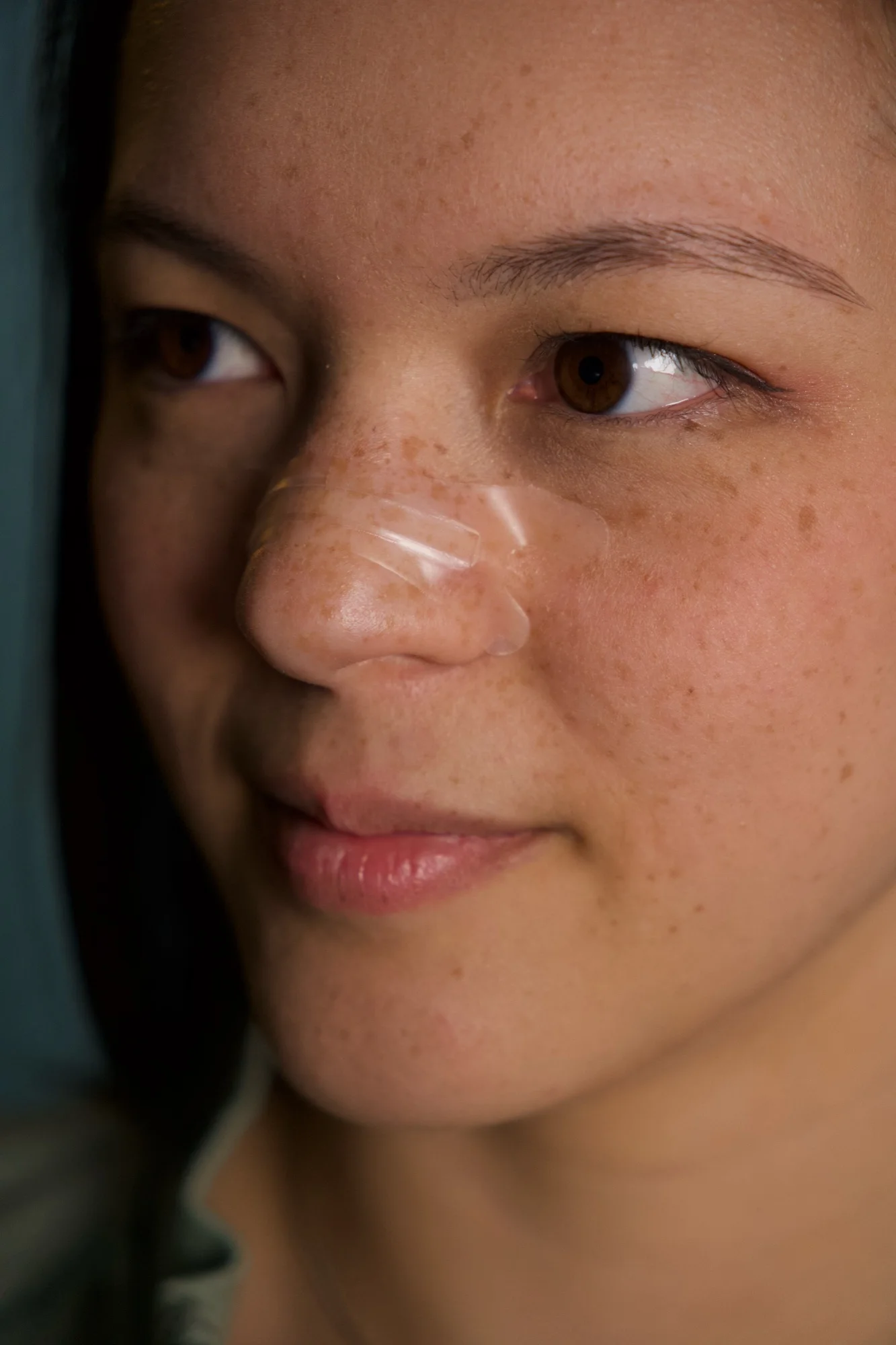 Nahaufnahme einer Person mit einem transparenten Nasenpflaster